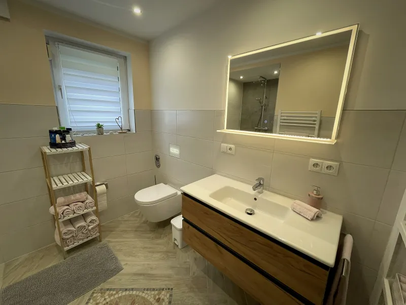 Badezimmer der Ferienwohnung Hanni mit Waschtisch und Spiegel
