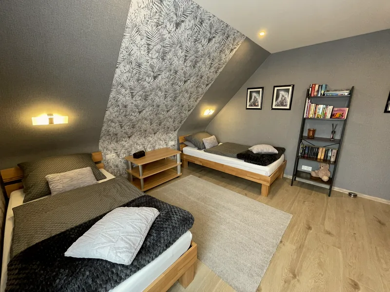 Zweites Schlafzimmer der Ferienwohnung Sofia: Zweibettzimmer unter der Dachschräge mit Blatt-Tapete